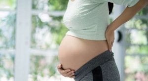 A pregnant woman holding her belly